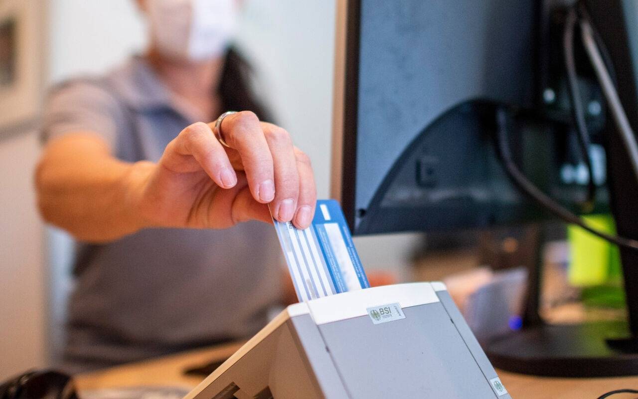 Eine Person schiebt eine Versichertenkarte einer Krankenkasse in eine Lesegerät. Elektronische Rezepte und digitale Patientenakten sollen nach jahrelangen Verzögerungen auf breiter Front zum Einsatz kommen. Darauf zielen Gesetzespläne von Gesundheitsminister Lauterbach (SPD), die das Bundeskabinett am Mittwoch in Meseberg auf den Weg gebracht hat.