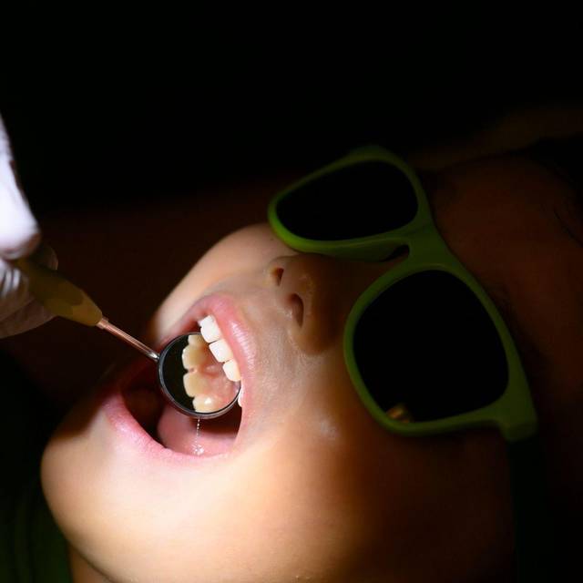 Eine Kinderzahnärztin untersucht ein dreijähriges Kind