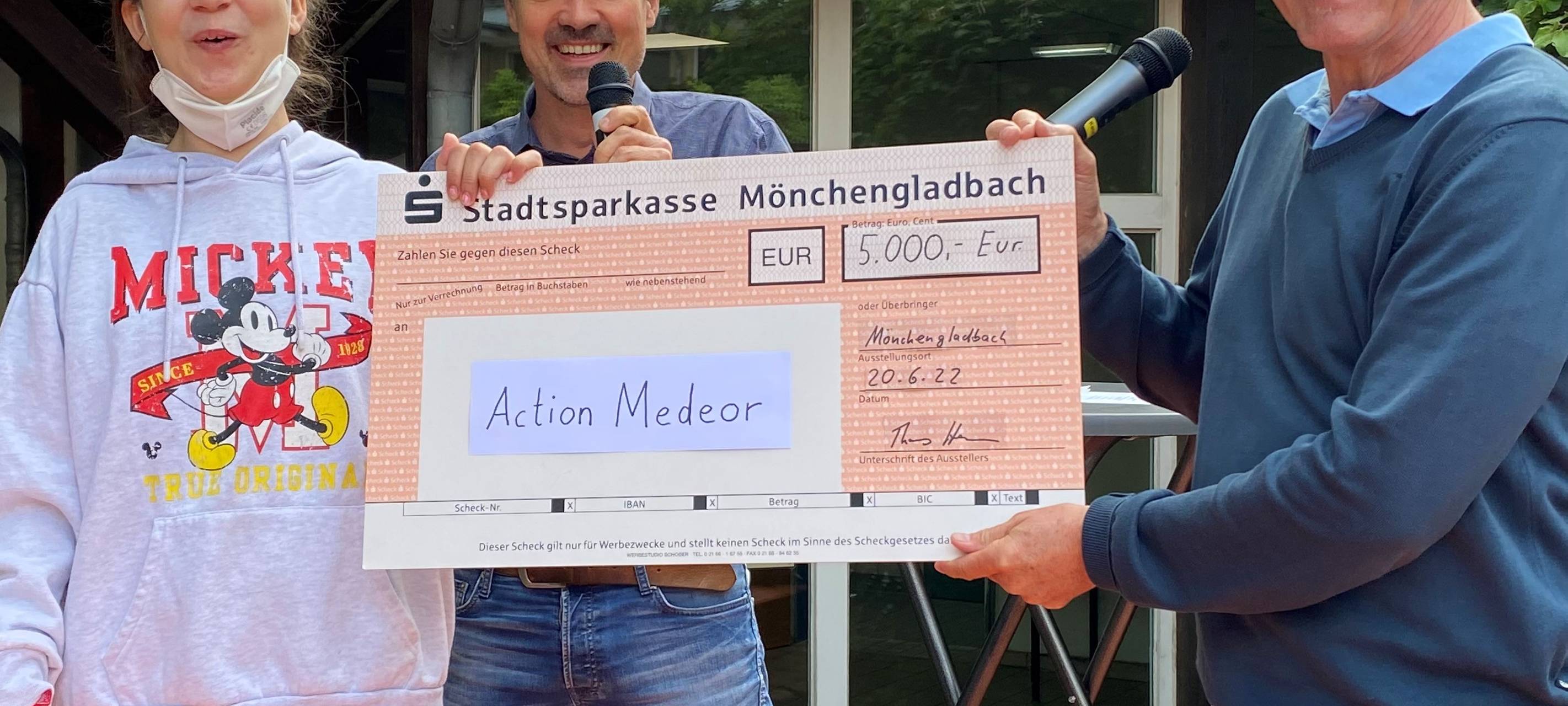 Stellvertretende Schülersprecherin und Schulleiter übergeben den Scheck.