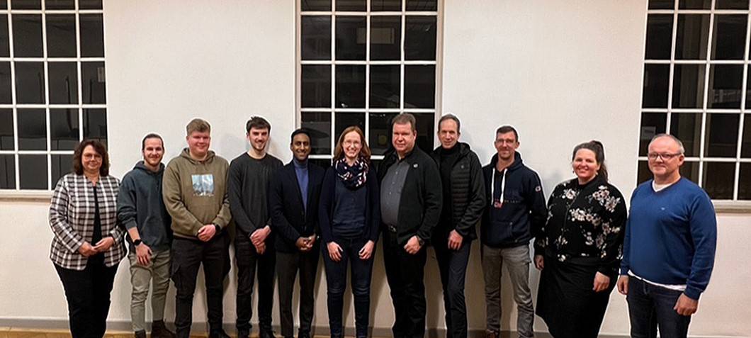 Elf Menschen stehen vor einer Fensterfront. Sie haben gerade den Verein CodeclubMG gegründet.