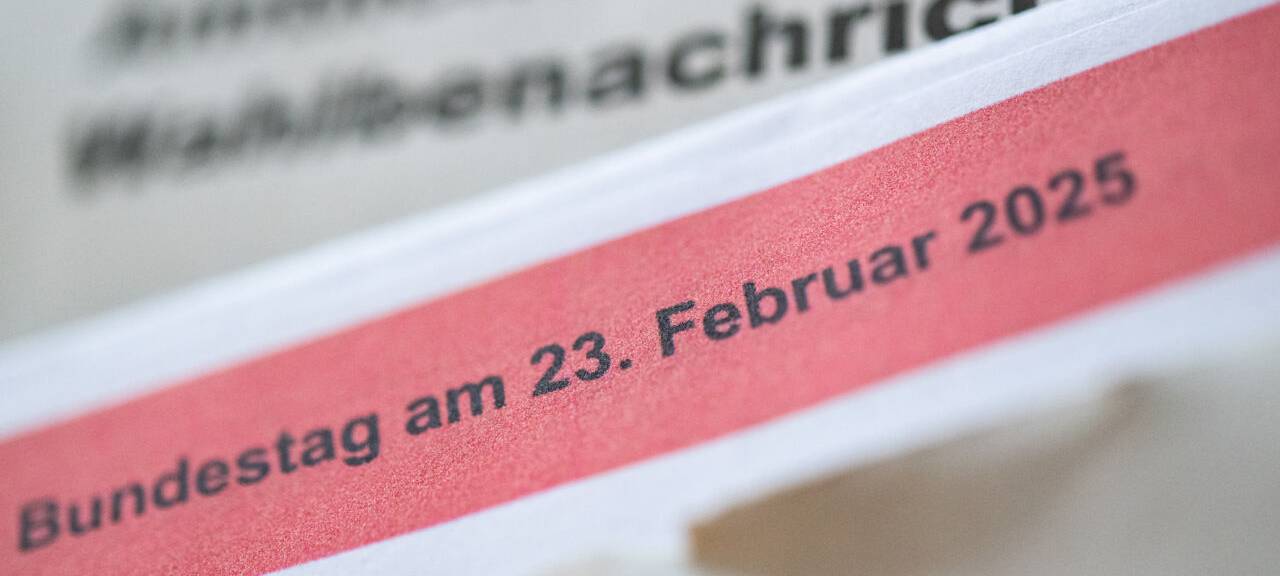ine geöffnete amtliche Wahlbenachrichtigung zur Wahl zum deutschen Bundestag am 23. Februar 2025 liegt auf einem Tisch.