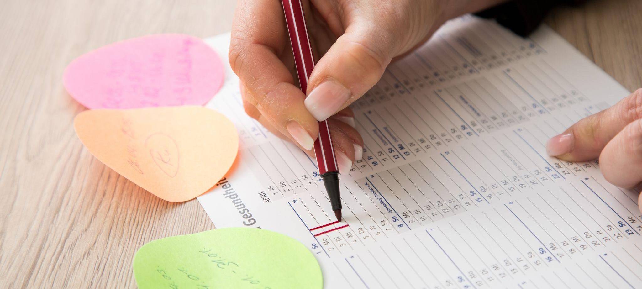 Eine Frau makiert Urlaubstage in einem Kalender