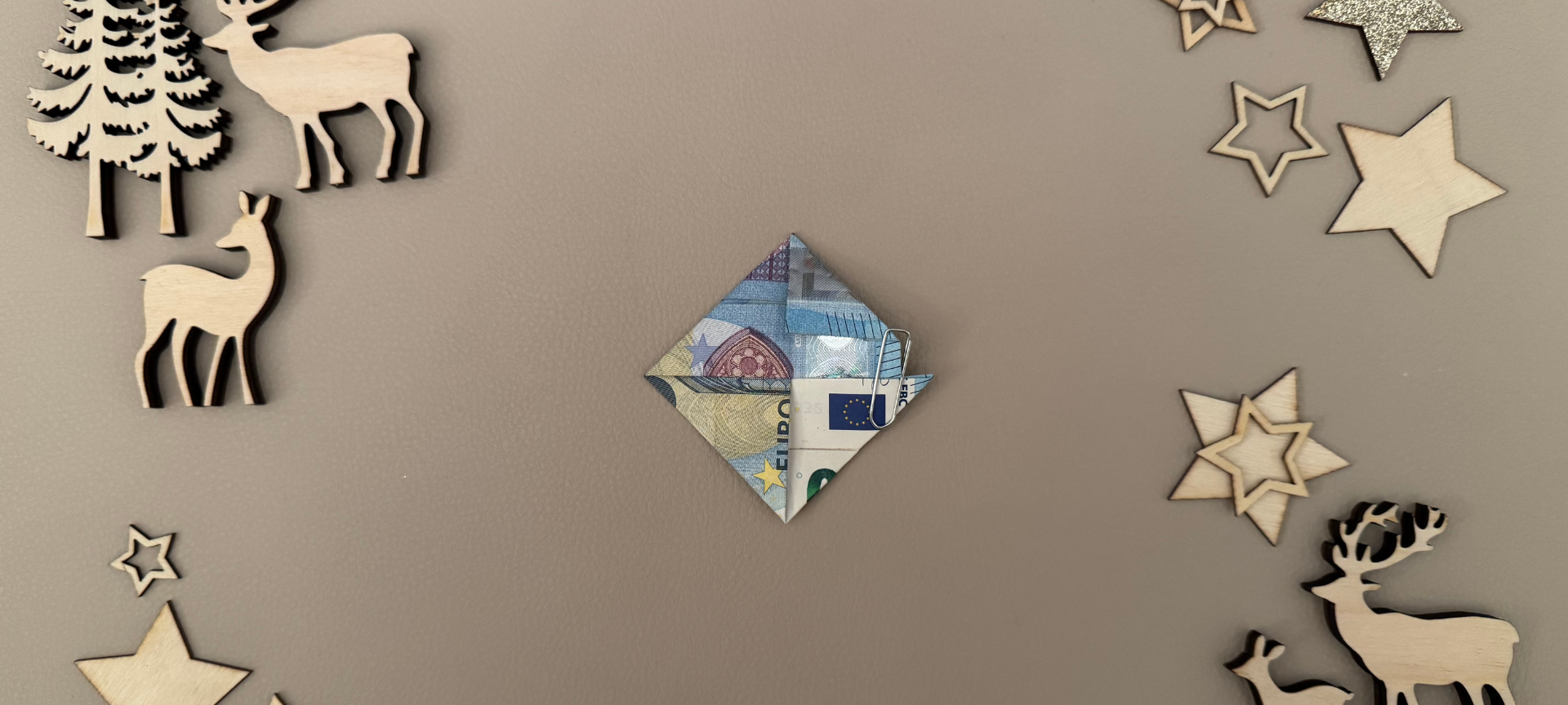 8. Erneut den Geldschein um 90° gegen den Uhrzeigersinn drehen und erneut den rechten, oberen Teil des Geldscheins an der Falzlinie nach unten falten. Nun entsteht eine Rautenform.